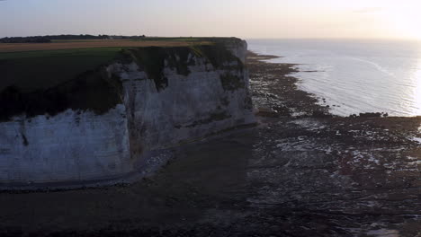 descending aerial shot over the steep cliff of the french normandy at sunset