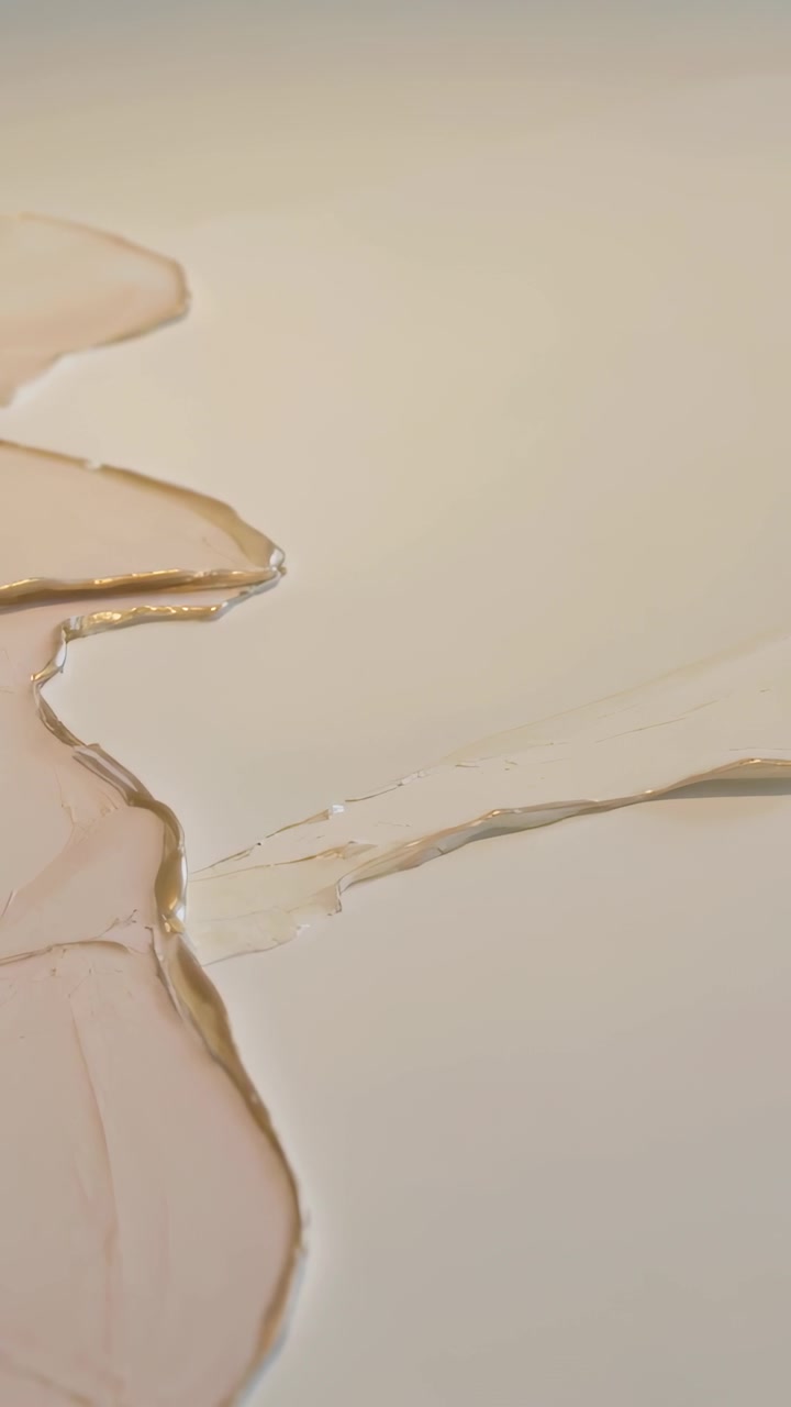 Video verticale: Registrazione di resina lucida beige-rosa che si espande e si livella su una scrivania con bordo dorato, spazio per il testo.