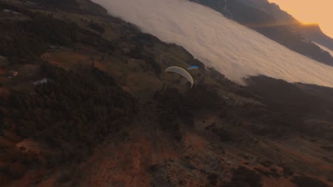 paragliding over mountain valley at sunset