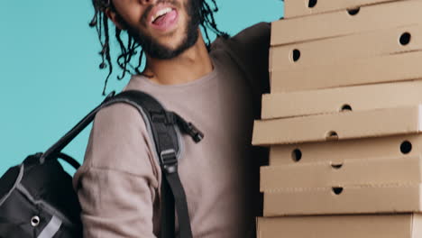 portrait of smiling pizza delivery man holding takeaway orders, blue background