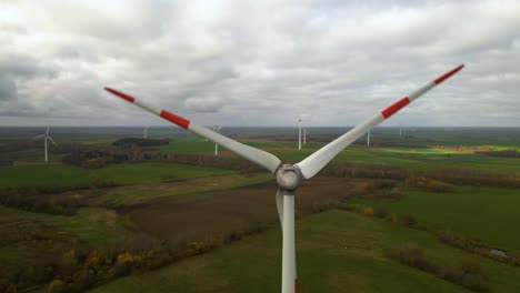 aerial shot of multiple rotating wind turbines for renewable electric power production in a wide rural area