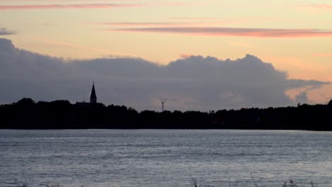 Windrad-Neben-Einer-Kirche,-Die-Erneuerbare-Energien-In-Einem-Dorf-Demonstriert