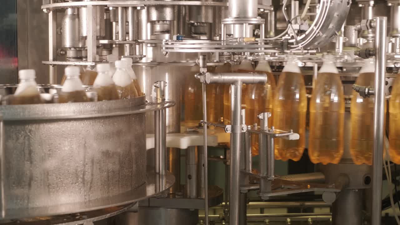 Automatisk påfyldningsmaskine hælder vand i plastik PET-flasker på moderne drikkevarefabrik