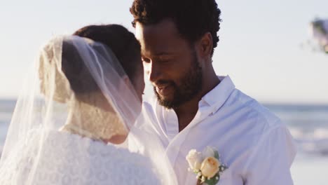 Una-Pareja-Afroamericana-Enamorada-De-Casarse,-Mirándose-En-La-Playa