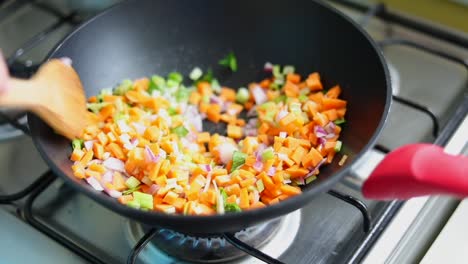 person stir fry chopped mix vegetables in pan