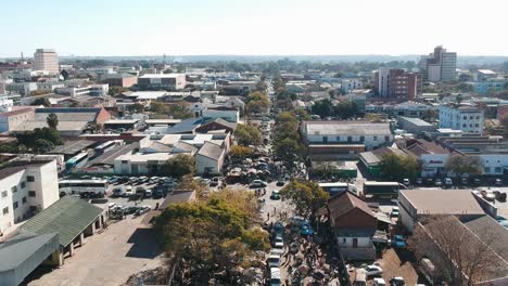 a pull back drone shot of crowded city road under sunny conditions