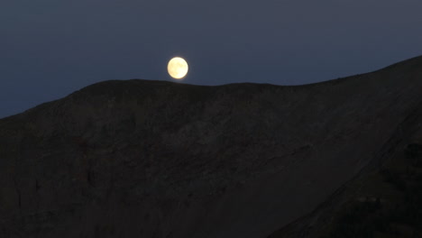 vista aérea de una línea de cresta y una luna llena justo encima de ella en las montañas rocosas de colorado