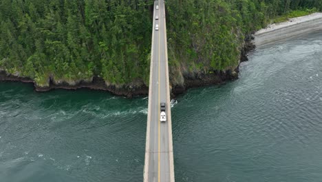 Vista-Aérea-De-Un-Camión-Que-Transporta-Un-Bote-A-Través-Del-Paso-De-Engaño-En-La-Isla-Whidbey