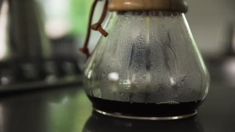 freshly brewed black coffee in glass carafe on kitchen counter at home