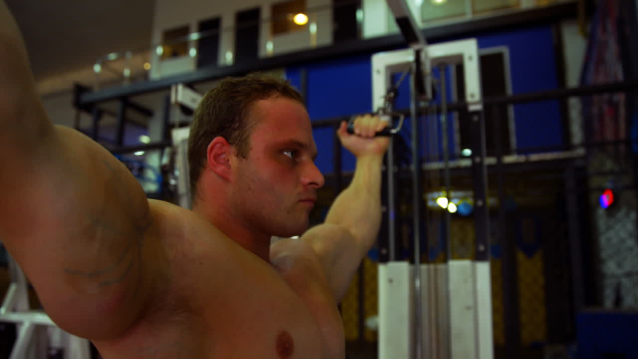 높은 케이블 비셉스 컬러로 운동하는 남자