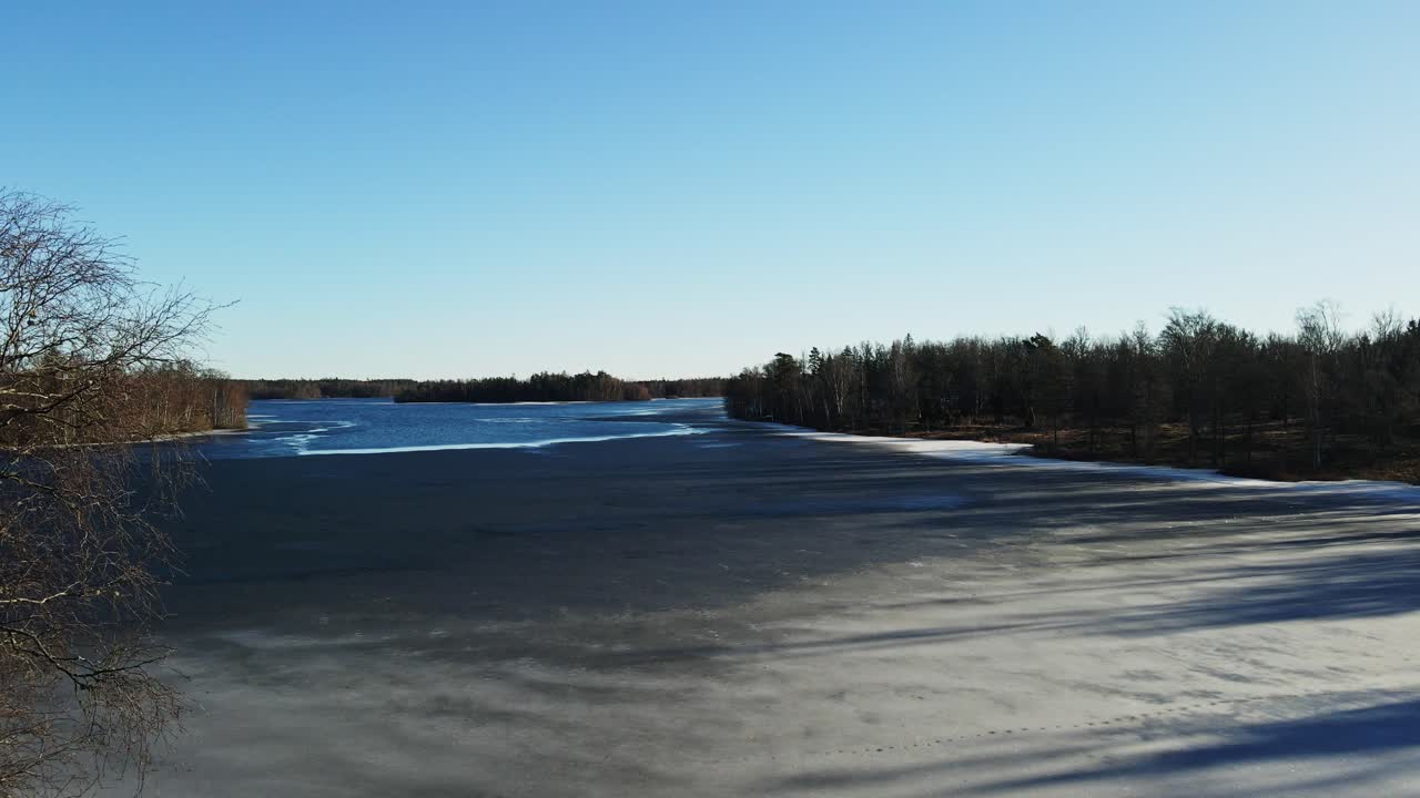 Jib up of a beautiful frozen lake in rural Sweden on a sunny winter day