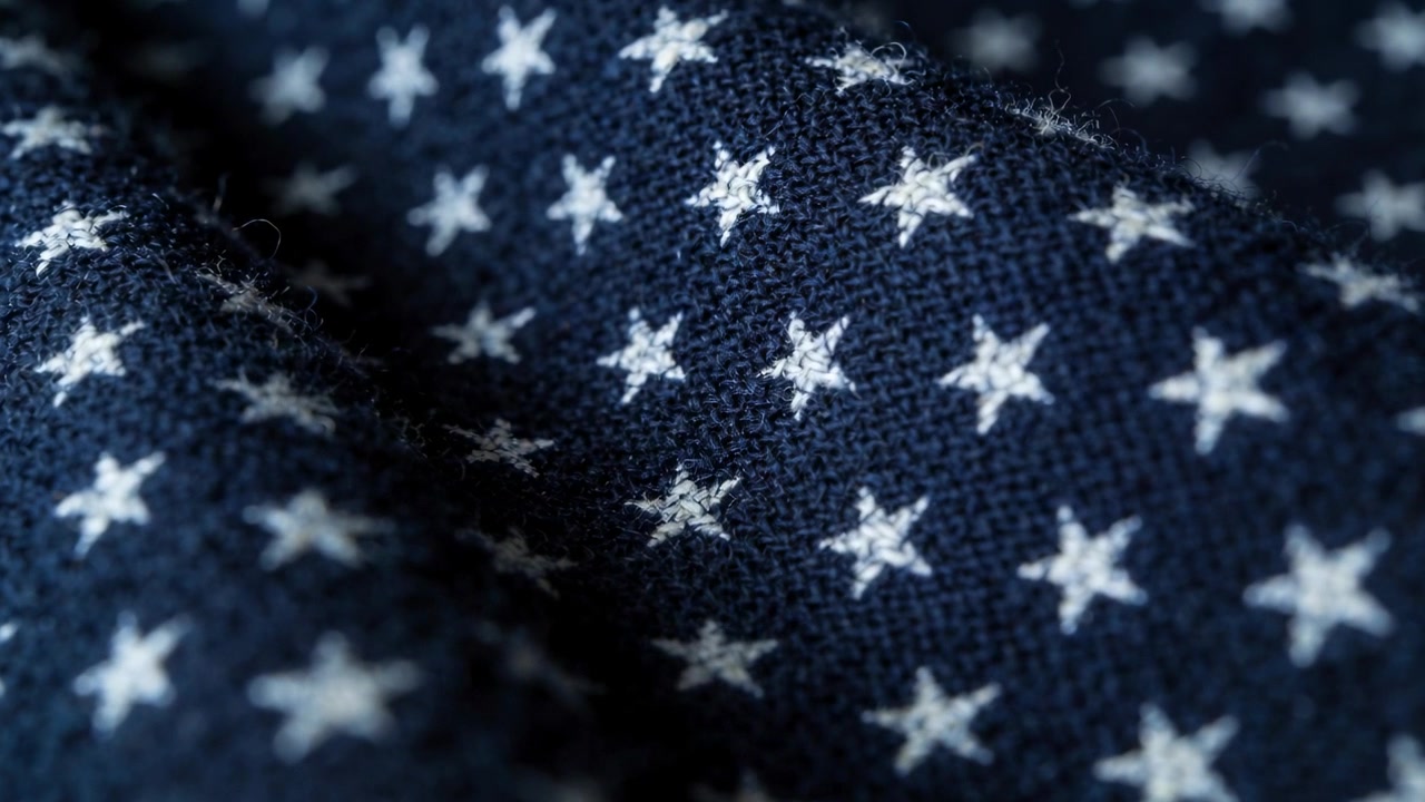 Pulling focus camera revealing navy starred fabric studio, showing weave and fold to accent texture