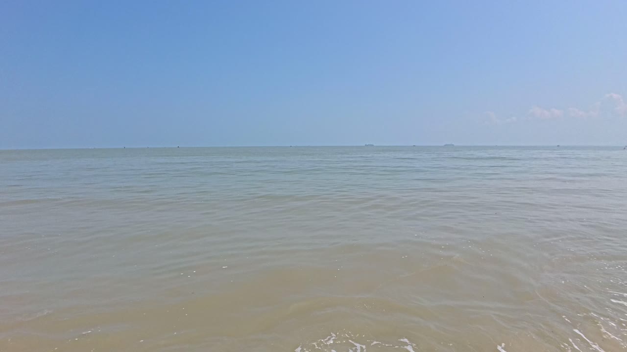 A serene seascape with gentle waves under a clear blue sky