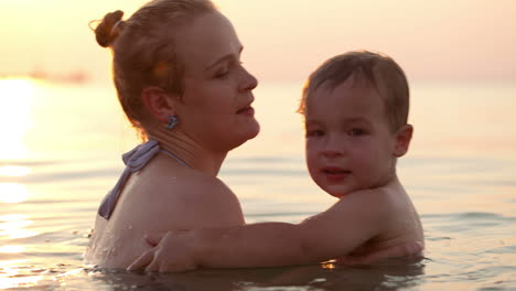 son and mother embracing in the sea