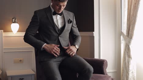 apuesto novio hombre de negocios con chaqueta gris en casa en la sala de estar, camisa blanca con corbata negra