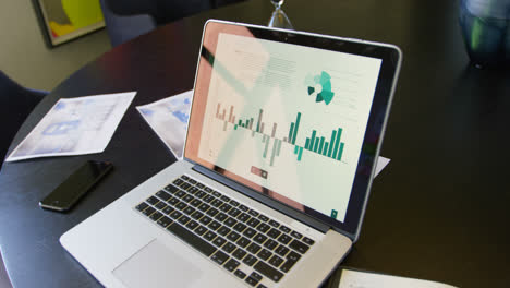 Close-up-of-laptop,-mobile-phone-and-documents-on-the-table-in-conference-room-of-modern-office-4k