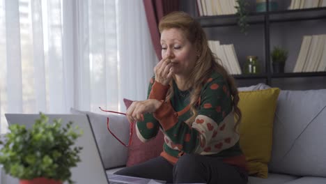 dolor en los ojos. una mujer madura que trabaja mucho mira su computadora portátil en casa.