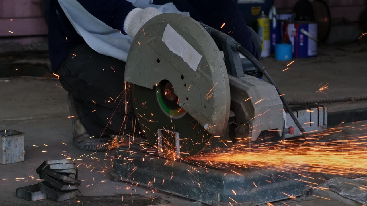 hombres profesionales que usan gafas de protección y guantes de construcción trabajan en talleres caseros con máquinas eléctricas de corte de acero. el corte de metal hace que las chispas vuelen, en primer plano