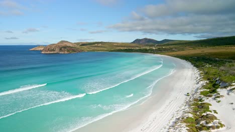 Aerial-view-of-a-4WD-car-in-the-beach,-waves---Lucky-Bay,-Australia---forward,-drone-shot