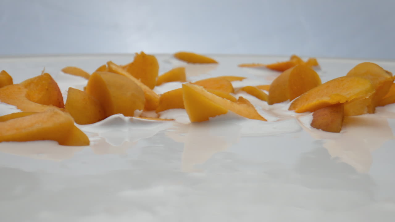 크리미 요거트 조각 아브리코스 배경 가까이. 우유 디저트에 누워 있는 과일