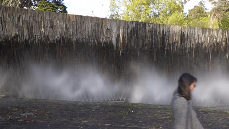 woman traveler passing in front of a fountain in coimbra city, portugal