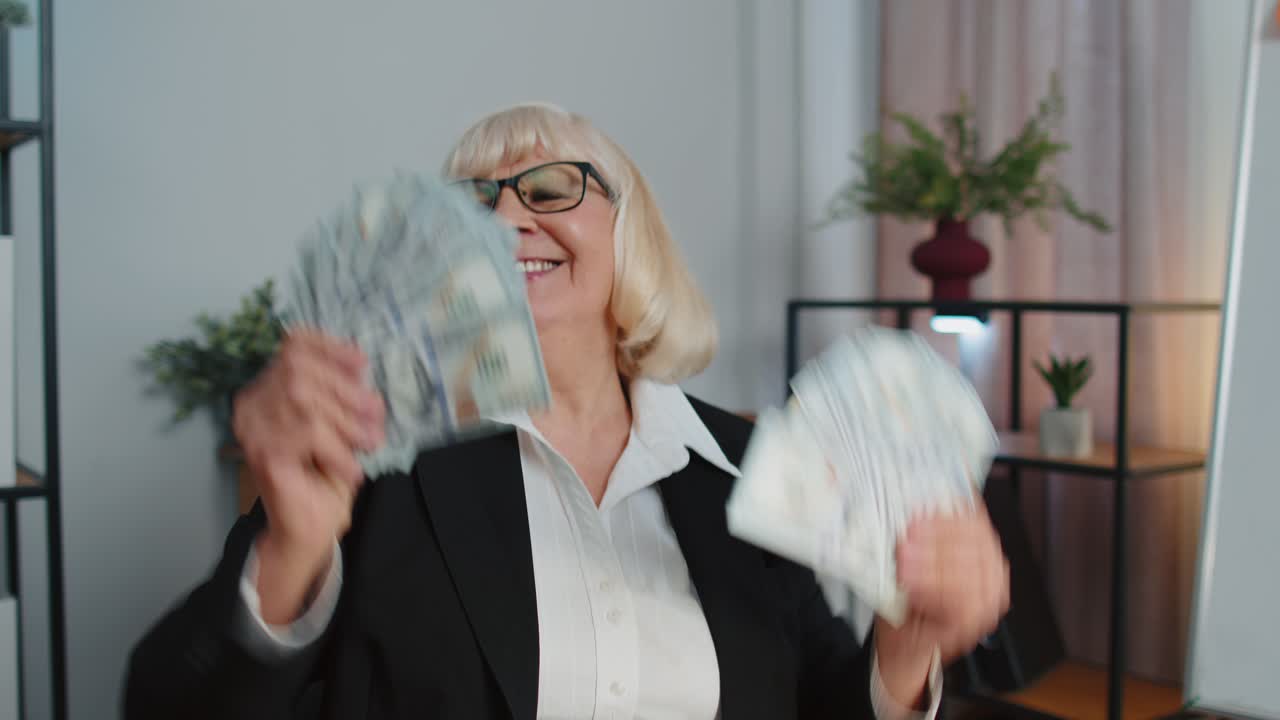 사업 성공을 축하하는 여성 회계사는 돈 한 어리와 함께 춤을 추고 있습니다.