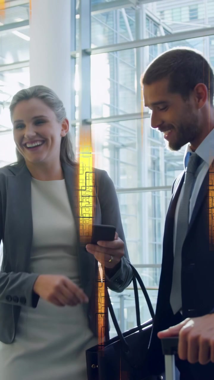 Video verticale: Due professionisti che entrano in un atrio di vetro controllando il telefono, stretta di mano che genera un bagliore, condividendo informazioni.