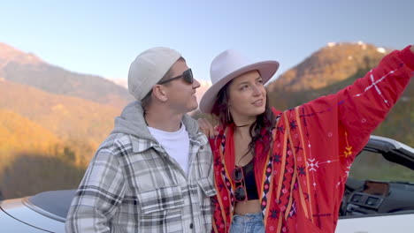 couple enjoying scenic mountain view from convertible car