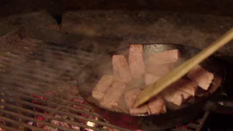 Campfire-cooking:-Thick-ham-slices-flipped-in-iron-pan-using-spatula