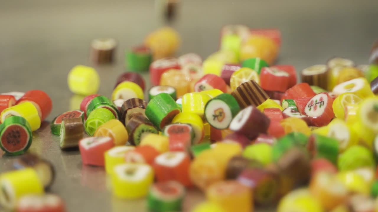 Sweet colorful caramel fruit candies bouncing and falling in slow motion
