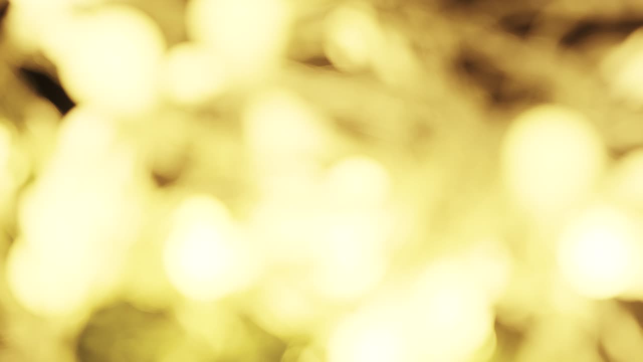 4k. bokeh borroso y parpadeante de fondo amarillo o dorado. fondo de vacaciones de año nuevo o navidad. espalda festiva brillante