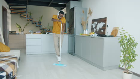 man cleaning the floor while listening to music