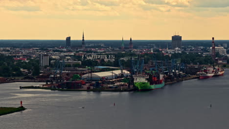 Aerial view of Riga port with city skyline and docked cargo ships