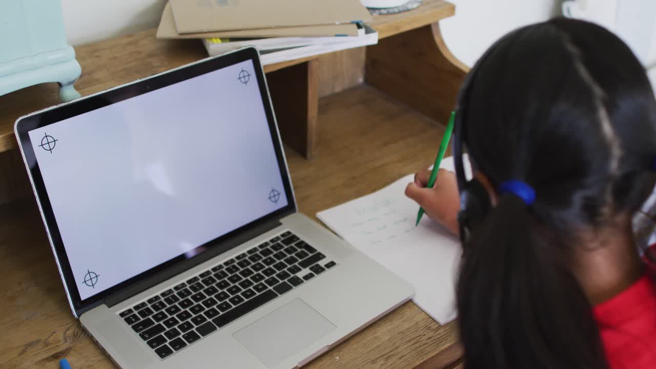 chica de raza mixta en casa en clase escolar en línea, usando auriculares y portátil con espacio de copia en la pantalla