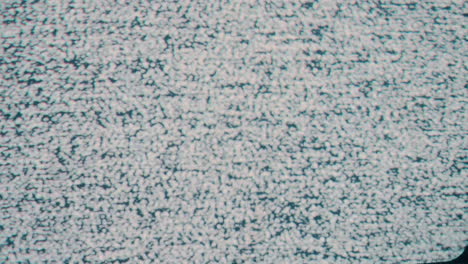 a close-up static shot capturing the iconic snow-like pattern of tv static noise