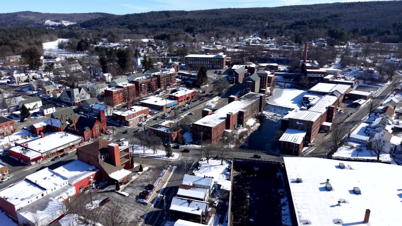 Luftfoto af røde industribygninger af mursten i sneklædt bymiljø i Ware på en vinterdag, Massachusetts, USA