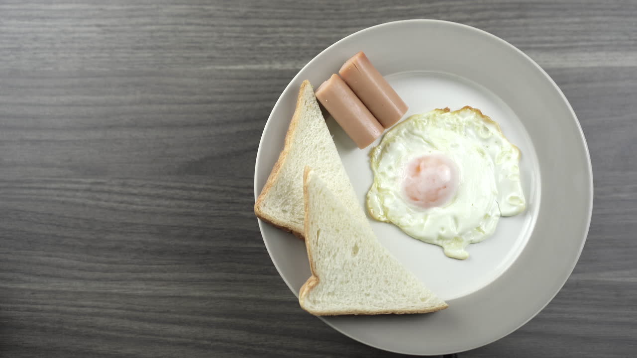 Close Up Top View Shot rotating.Breakfast on a white plate on the right corner of the wooden floor