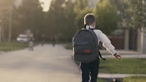 cu tracking slow motion back view shot student after school hours runnning home