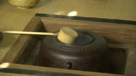 steam rises from a cast iron tea kettle