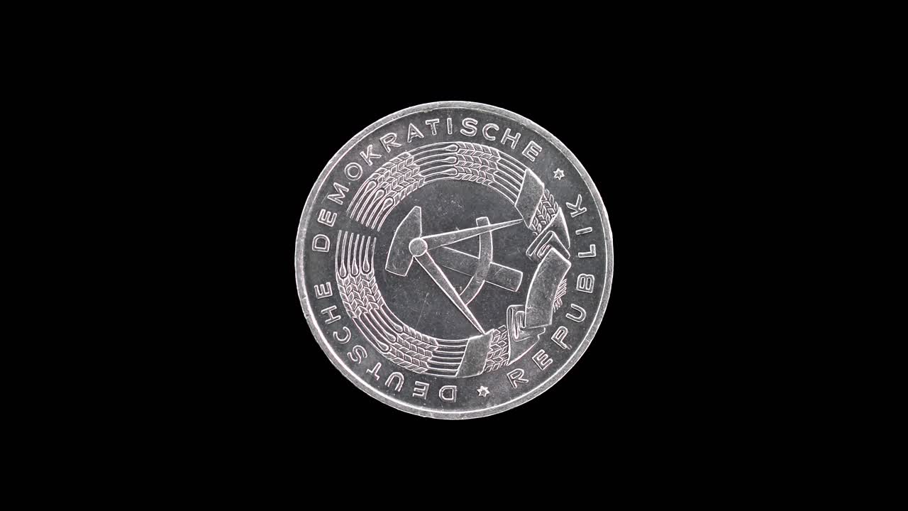 East Germany 1968 1 pfennig coin obverse with national emblem rotating on black background
