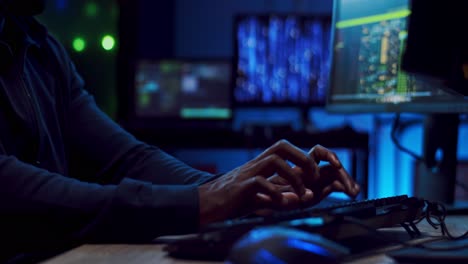 primer plano del joven hacker o desarrollador de software tocando, escribiendo y enviando mensajes de texto en el teclado de la computadora por la noche mientras programa