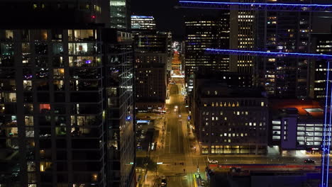 Aerial-view-over-traffic-on-illuminated-streets,-night-in-downtown-Phoenix,-USA