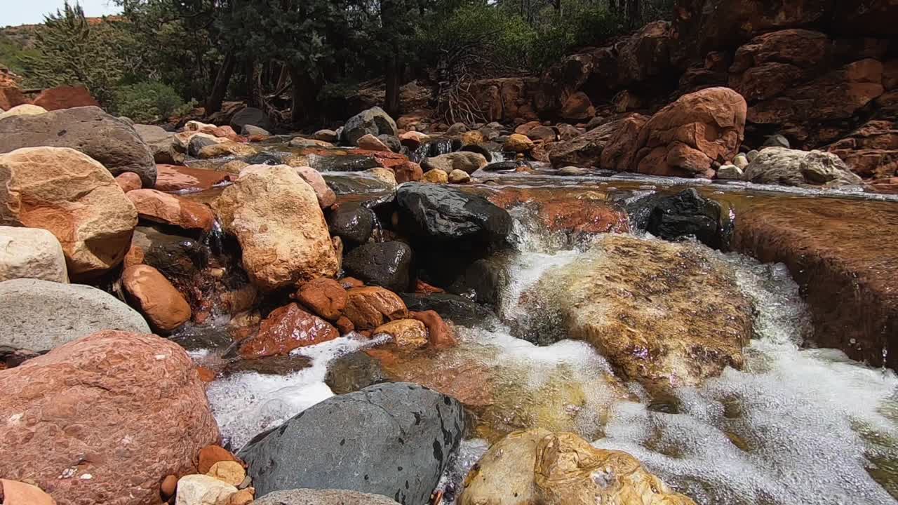 Close up of the swollen spring runoff from Oak Creek rushes over rocks and boulders in the creek bed, Sedona, Arizona.