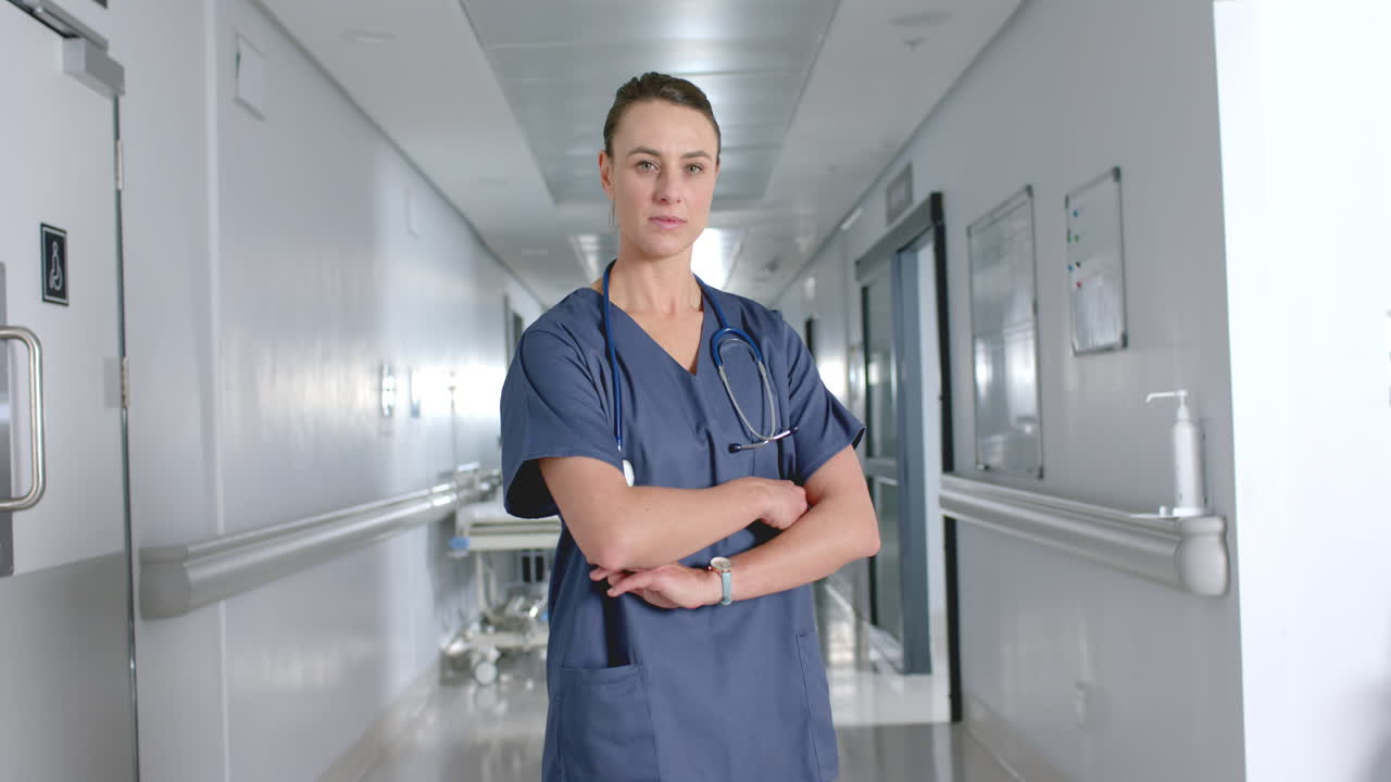 una mujer caucásica segura de sí misma está de pie en un pasillo del hospital.