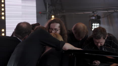 musicians working on a piano