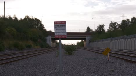 timelapse of irish rail trains traveling through the railroads with do not trespass on the railway warning sign