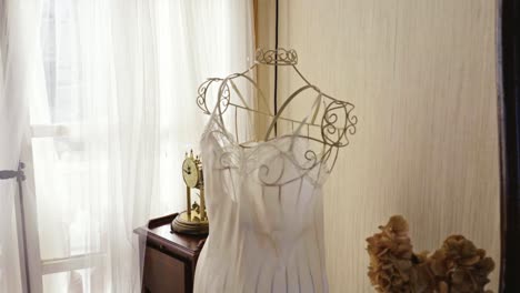 lingerie dress displayed on a rack in a room with antique decoration and lots of natural light