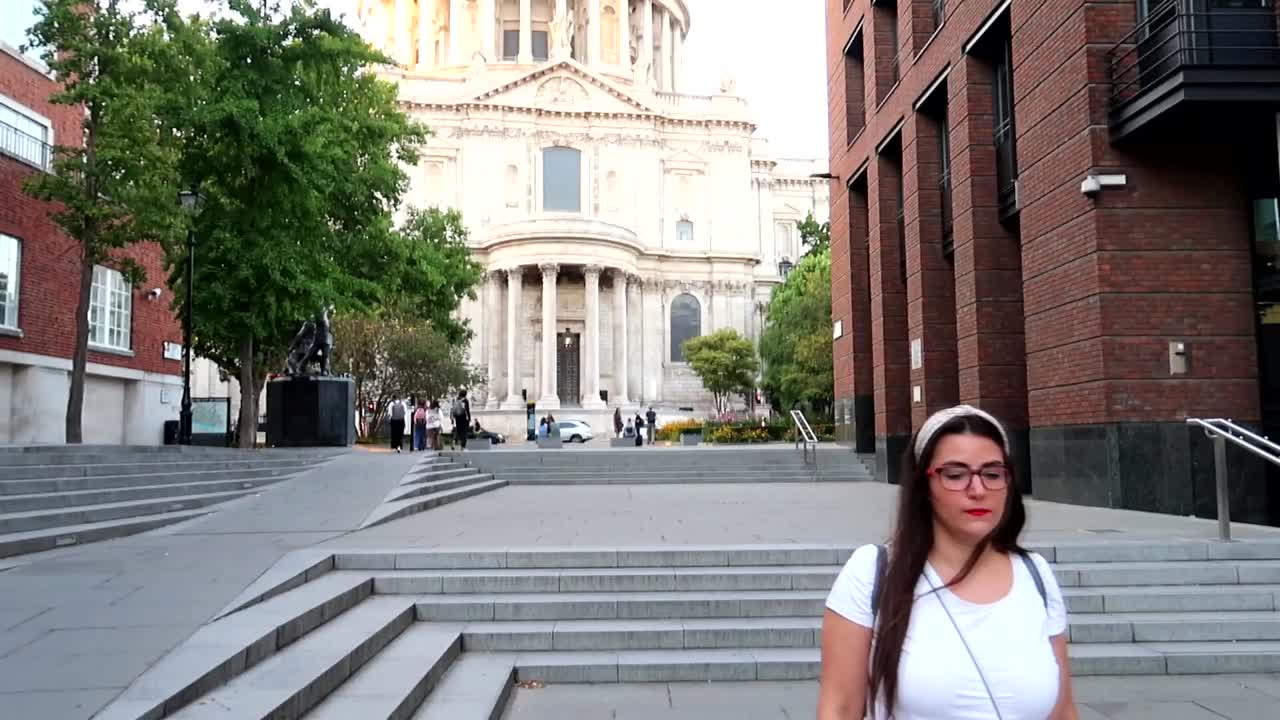 Lone pretty woman walks in the City of London with St Paul's Cathedral in background