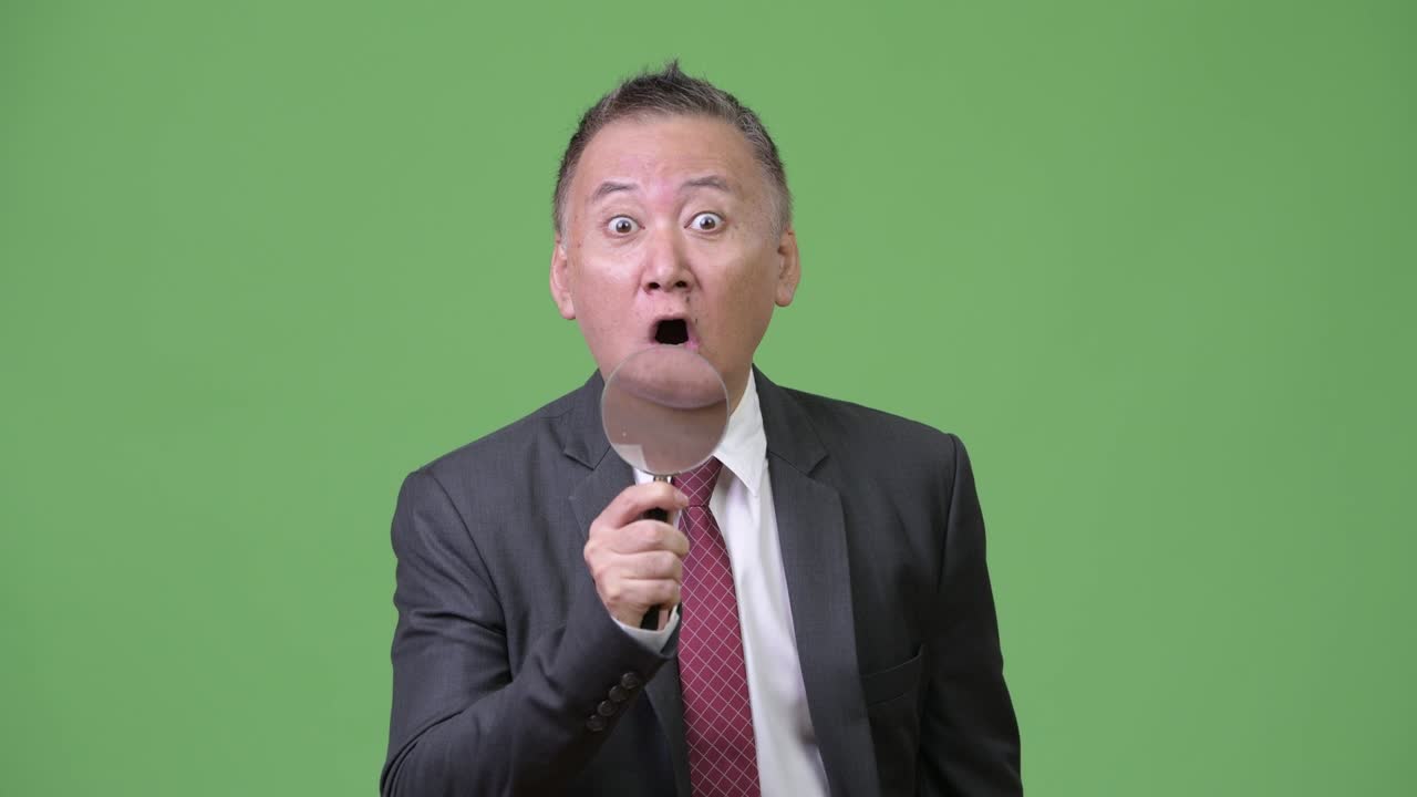 성숙한 일본 사업가가가 보기를 사용한다.