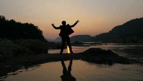 silhouette of a man at sunset by the river